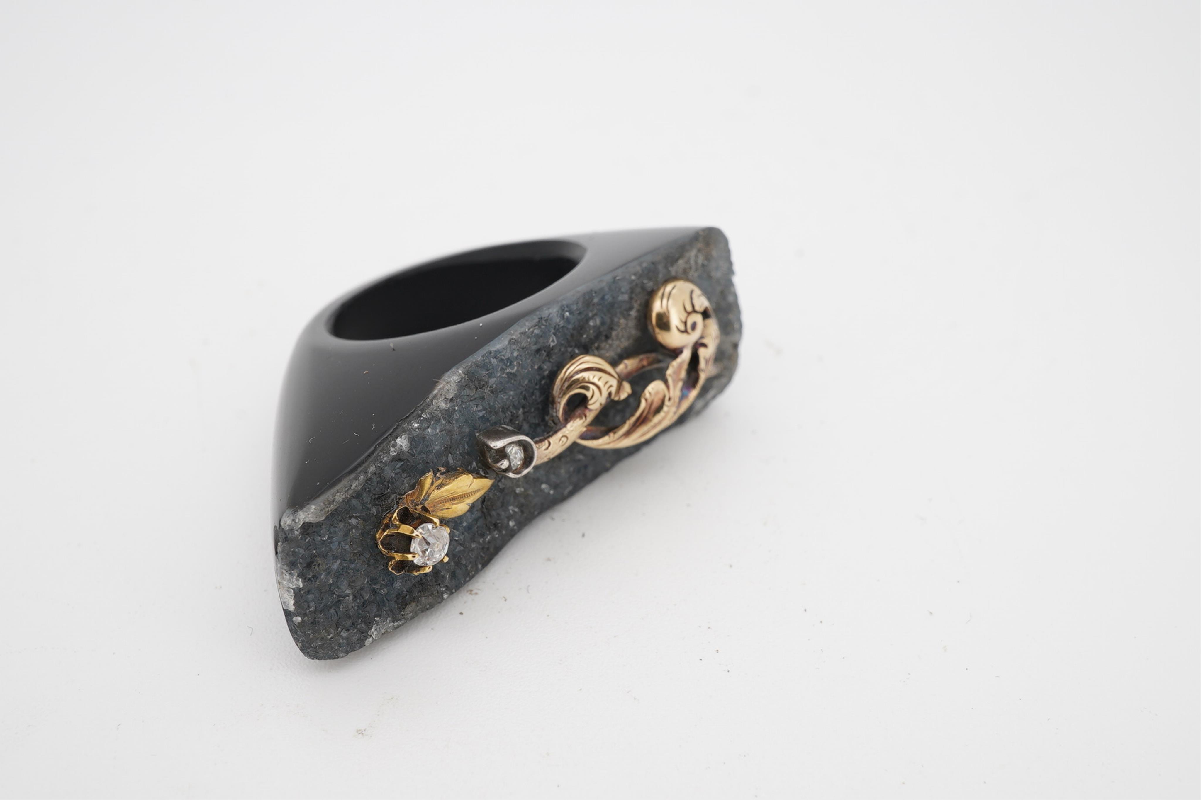 An unusual quartz ring, with a yellow metal and two stone diamond set scrolling foliate surmount, size N/O.